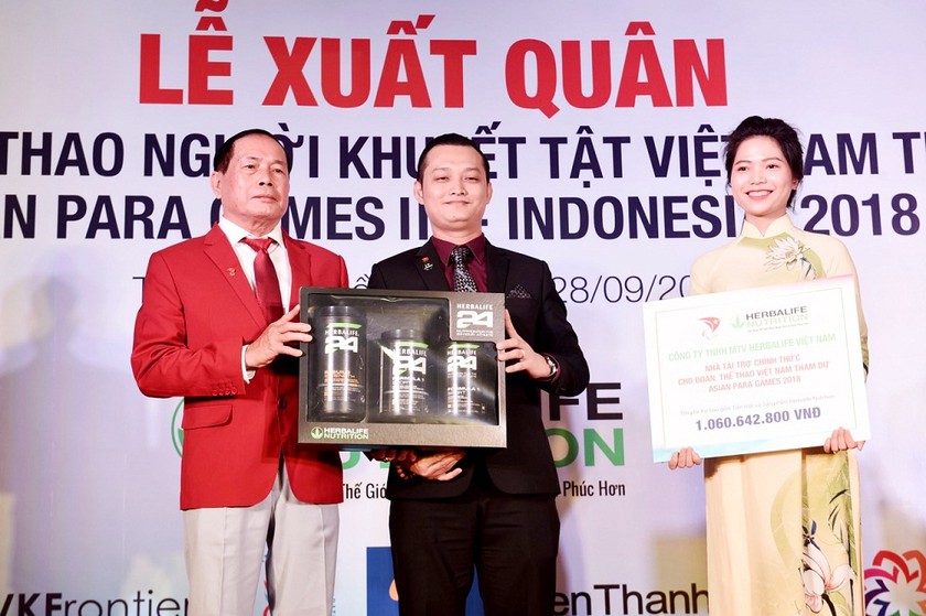 Ông Phạm Tường Huy (Tổng Giám đốc Herbalife Việt Nam) trao tặng bảng tượng trưng và sản phẩm tượng trưng cho ông Vũ Thế Phiệt (Phó Chủ Tịch kiêm Tổng Thư Ký Ủy Ban Paralympic Việt Nam ) - đại diện đoàn thể thao người khuyết tật Việt Nam