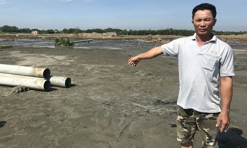 Ông Nguyễn Văn Tùng trên phần đất đã bị cưỡng chế, đang được bơm cát san lấp mặt bằng