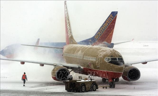 Máy bay bị phủ kín tuyết sau trận bão tuyết ở sân bay Midway thuộc Chicago, Mỹ. Ảnh tư liệu: AFP/TTXVN