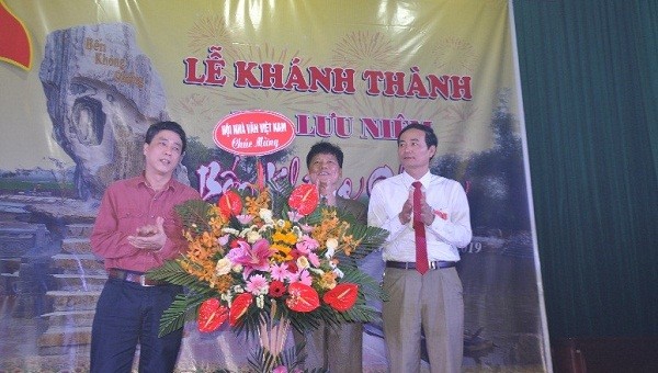 Nhà văn Nguyễn Bình Phương (trái) - Ủy viên BCH Hội Nhà văn Việt Nam tặng lẵng hoa chúc mừng Nhà văn Dương Hướng