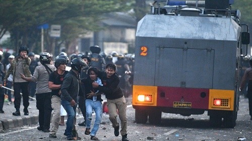 Cảnh sát Indonesia bắt người biểu tình ở thủ đô Jakarta. Ảnh: Reuters/VnE