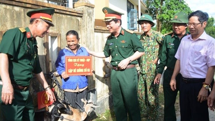 Thiếu tướng Nguyễn Văn Bình, Phó Chính ủy TCKT và lãnh đạo xã Hướng Hiệp, huyện Đa Krông trao dê giống tặng các gia đình người có công trên địa bàn. Ảnh Duy Thành