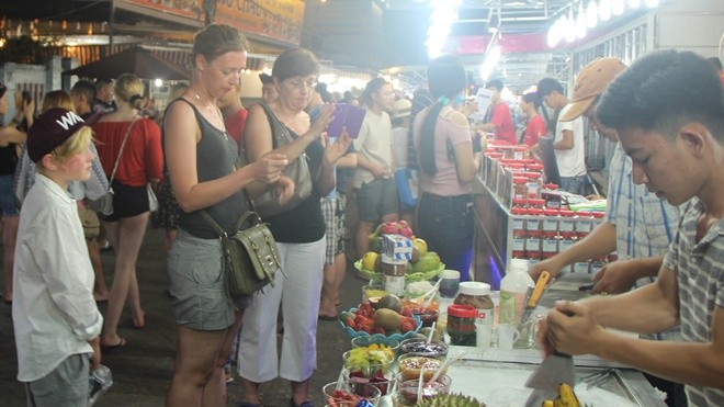 Du khách quốc tế tham quan, mua sắm ở chợ đêm Phú Quốc. Ảnh CAND