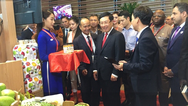 Phó Thủ tướng Phạm Bình Minh và các đại biểu tham quan các gian hàng được trưng bày bên lề Hội nghị