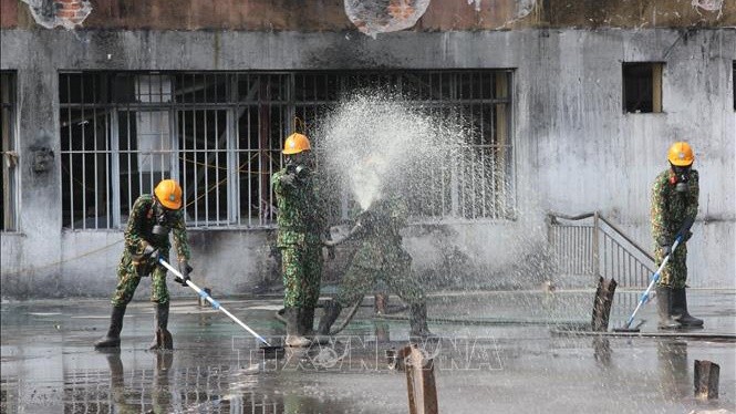 Lực lượng Binh chủng Hoá học tiến hành tẩy độc mặt nền nhà xưởng của Công ty Rạng Đông, ngày 5/10. Ảnh: Dương Giang/TTXVN