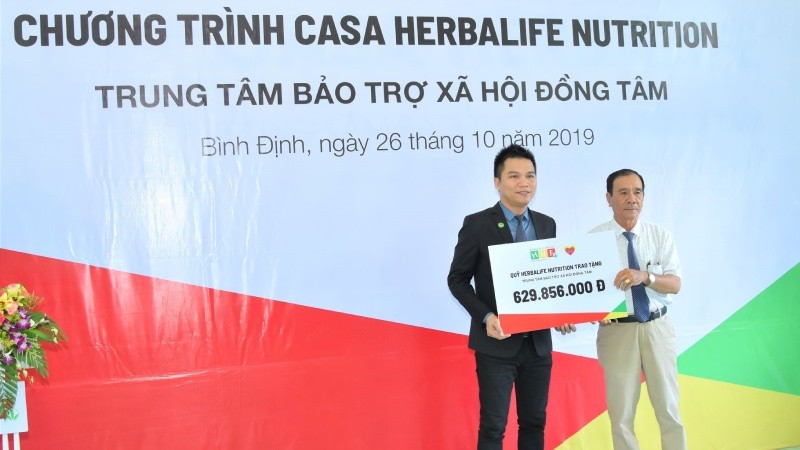 Ông Nguyễn Thành Đạt (trái) - Giám đốc Truyền thông Herbalife Việt Nam đại diện công ty trao tặng hơn 629 triệu đồng cho TTBTXH Đồng Tâm