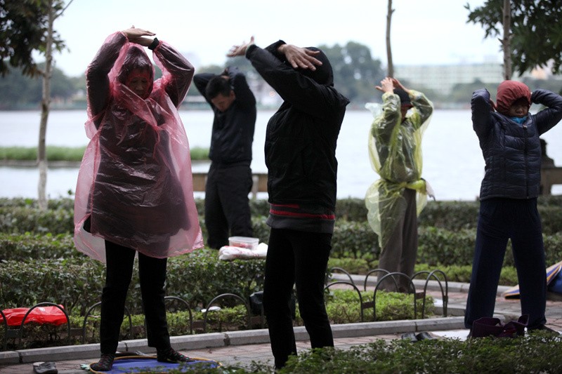 Người Hà Nội mặc áo mưa tập thể dục tránh gió lạnh. (Ảnh internet)