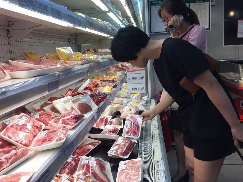 Khách hàng lựa chọn thịt lợn trong một siêu thị