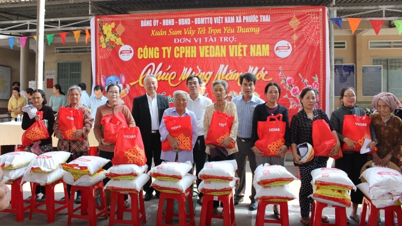 Ông Hsieh Jau Hwang - Trưởng sách lược Vedan Việt Nam (người đứng thứ 1 từ trái qua) trao quà Tết cho bà con xã Phước Thái, huyện Long Thành