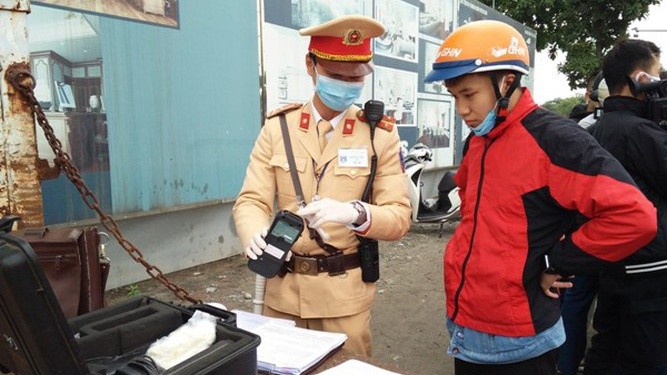 Cảnh sát giao thông Hà Nội đeo khẩu trang, găng tay và sát trùng dụng cụ kiểm tra nồng độ cồn