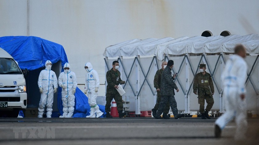 Nhân viên y tế làm nhiệm vụ gần du thuyền Diamond Princess bị cách ly tại cảng Yokohama, Nhật Bản ngày 13/2. (Ảnh: AFP/TTXVN)