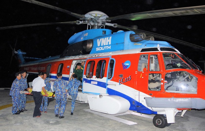 Bệnh nhân được vận chuyển lên trực thăng đưa về đất liền cấp cứu. (Nguồn: TTXVN)