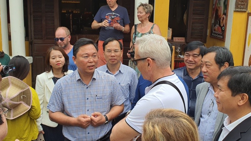 Chủ tịch tỉnh Quảng Nam Lê Trí Thanh (bên trái) xuống đường trò chuyện với du khách ngày 22/2