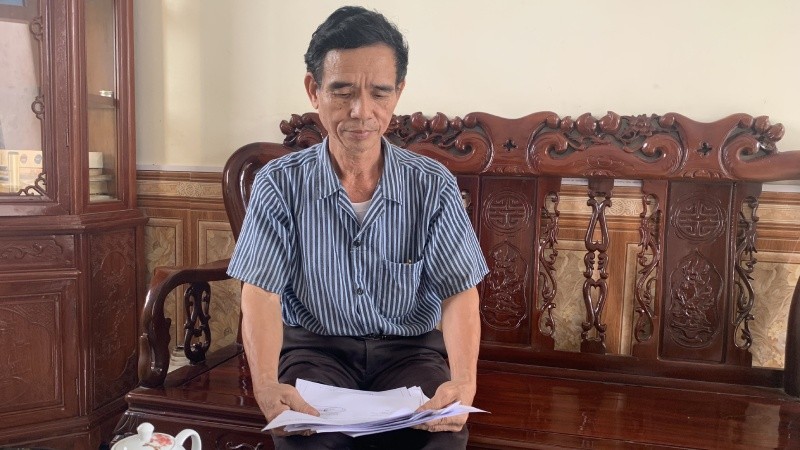 Ông Trần Thành Đồng bên tập hồ sơ tài liệu liên quan đến vụ án tranh chấp đất đai