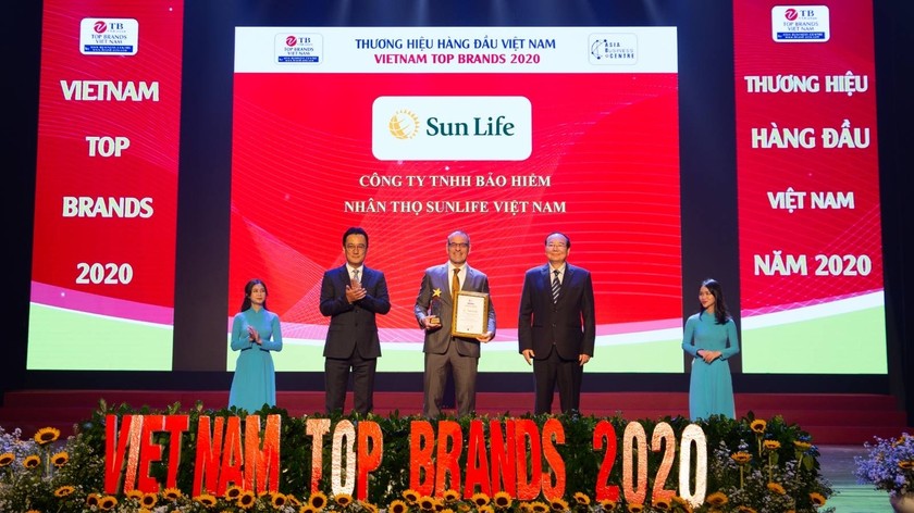 Ông Larry Madge - Tổng Giám đốc Sun Life Việt Nam (đứng giữa) nhận danh hiệu Top 10 Thương hiệu hàng đầu Việt Nam từ Ban tổ chức.