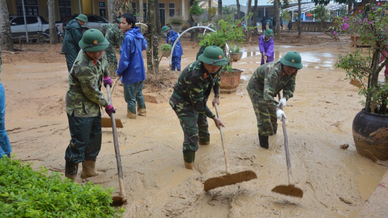Cán bộ, nhân viên Đoàn KT-QP 337 giúp dân dọn bùn sau mưa lũ.