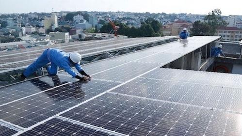 Công nhân lắp đặt điện mặt trời áp mái tại nhà xưởng công nghiệp.