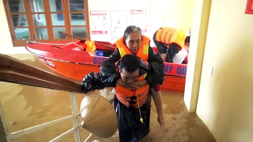 Bộ đội di dời dân bị ngập lụt đến nơi an toàn. 