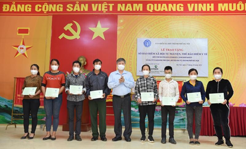 Ông Nguyễn Đức Hòa, Giám đốc BHXH TP Hà Nội trao sổ BHXH tự nguyện cho người dân tại xã Ba Vì và Khánh Thượng (huyện Ba Vì).