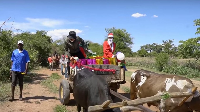 Hình ảnh Quang Linh cùng các cộng sự đi xe bò phát quà Giáng sinh và Tết Dương lịch cho người dân Angola.
