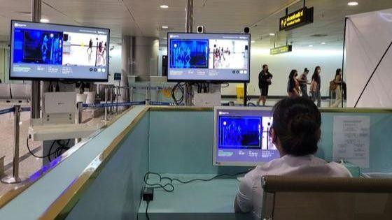 Nhân viên Cảng hàng không Quốc tế Tân Sơn Nhất kiểm tra thân nhiệt hành khách nhập cảnh. 