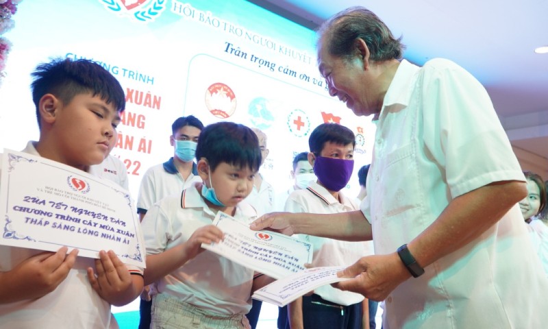 Nguyên Phó Thủ tướng Thường trực Chính phủ Trương Hòa Bình trao quà cho người khuyết tật và trẻ em mồ côi tại TP HCM. 