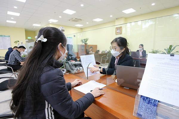 Cán bộ chi nhánh NHCSXH TP Hà Nội hướng dẫn người lao động vay vốn tín dụng