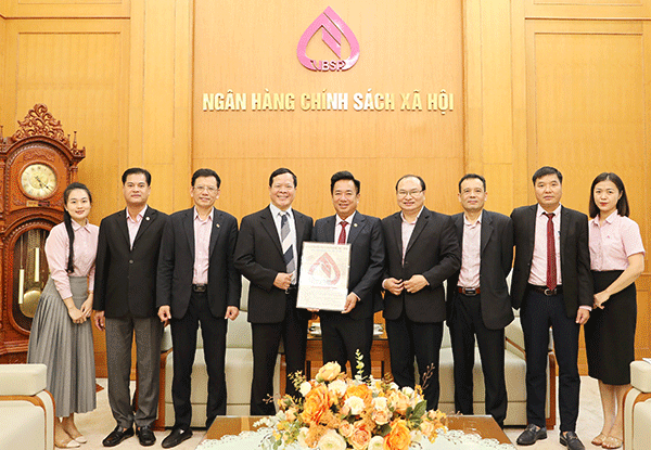 NHCSXH tiếp nhận biểu trưng Logo Ngân hàng Phục vụ người nghèo Việt Nam từ tác giả Dương Hồng Khánh. Ảnh VBSP