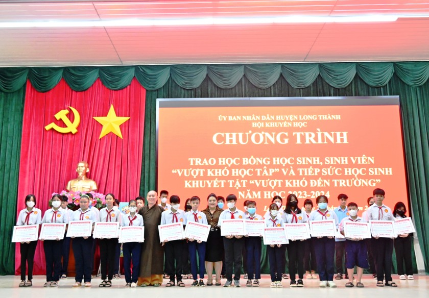 Bà Nguyễn Thu Thủy - Phó giám đốc đối ngoại Vedan Việt Nam (đứng giữa) trao học bổng cho các em học sinh.