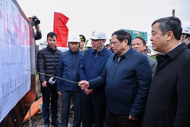 Thủ tướng Phạm Minh Chính và đoàn công tác nghe báo cáo tiến độ thi công dự án - Ảnh: VGP/Nhật Bắc