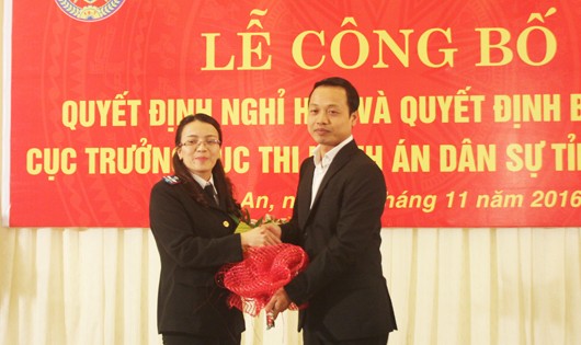 Thứ trưởng Trần Tiến Dũng trao quyết định và tặng hoa chúc mừng Cục trưởng Cục THADS Nghệ An cho bà Hoàng Thị Thu Trang. 