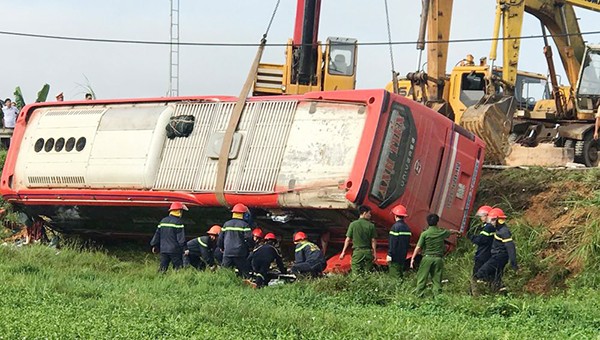 Lực lượng cứu hộ chiếc xe khách bị lật xuống ruộng bên đường Hồ Chí Minh