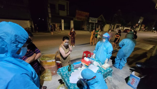Cán bộ y tế khẩn trương lấy mẫu ngay trong đêm khi phát hiện ca bệnh ở phường Hưng Dũng. (Ảnh: SN)