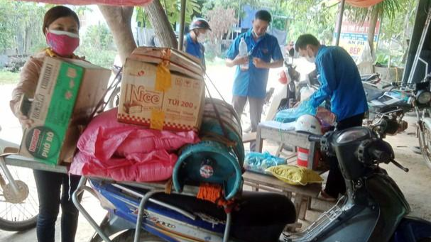 Chị Lộc Thị Thủ cùng các thanh niên tình nguyện chuẩn bị hàng hoá hỗ trợ người dân ảnh hưởng dịch. Ảnh: CSCC.