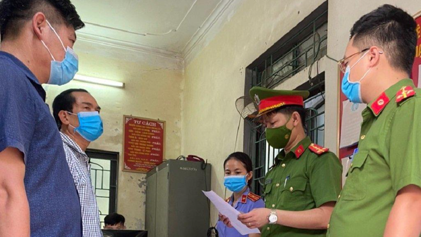 Tống đạt quyết định khởi tố đối với các bị can Nguyễn Bỉnh Khảng, Hoàng Văn Chắt (áo sọc trắng).