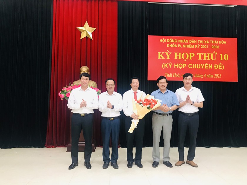 Thường trực HĐND tỉnh và đại diện các Sở, ban ngành cấp tỉnh tặng hoa chúc mừng tân Chủ tịch UBND thị xã Thái Hòa Chu Anh Tuấn.