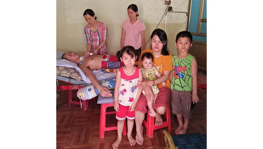 Chị Hà và 3 con nhỏ, bên người em chồng bị tai nạn lao động.