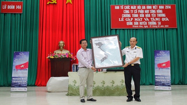  Ông Dương Văn Quynh - giám đốc Trung tâm triển lãm VHNT Việt Nam trao tặng bản sao thu nhỏ tấm bản đồ kỷ lục cho ông Nguyễn Văn Thắng- chính ủy lữ đoàn 146, vùng 4 hải quân.