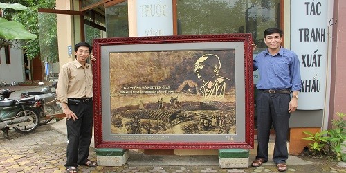 Anh Ổn (bên phải) và anh Tuyến bên bức tranh “Đại tướng và chiến thắng Điện Biên Phủ” tặng Bảo tàng Chiến thắng lịch sử Điện Biên Phủ.
