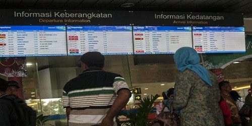 Hành khách kiểm tra lịch trình bay tại một sân bay ở Indonesia. Ảnh: AFP.