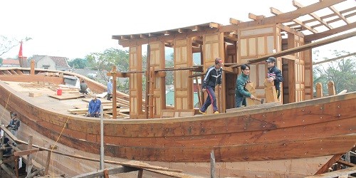 Thợ làng Trung Kiên đang hoàn thành con tàu để bàn giao cho ngư dân.