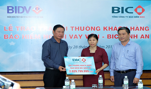 Tổng Giám đốc BIC Trần Hoài An (ngoài cùng bên trái) trao hơn 2 tỷ đồng tiền bảo hiểm BIC Bình An cho đại diện gia đình khách hàng Chu Thanh Phương (giữa)