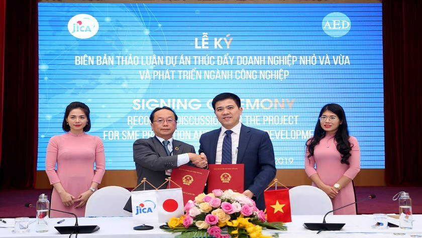 Ông Konaka Tetsuo, Trưởng Đại diện, Văn phòng JICA Việt Nam (đứng giữa, bên trái), và ông Lê Mạnh Hùng, Cục trưởng Cục Phát triển Doanh nghiệp, Bộ KH&ĐT (đứng giữa, bên phải), cùng nhau ký kết Biên bản Thảo luận