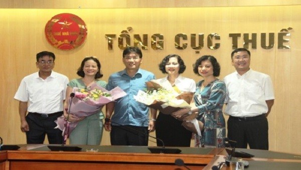 Ông Đặng Ngọc Minh - Phó Tổng cục trưởng Tổng cục Thuế (thứ 3 từ trái sang) trao quyết định, tặng hoa chúc mừng 2 lãnh đạo cấp vụ.