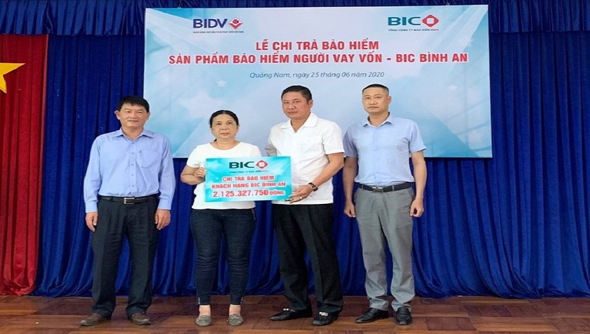 Ông Trần Hoài An, Tổng Giám đốc BIC và ông Nguyễn Bách Thọ, Giám đốc BIDV Quảng Nam, trao quyền lợi bảo hiểm cho đại diện gia đình khách hàng Đinh Văn Bạn.