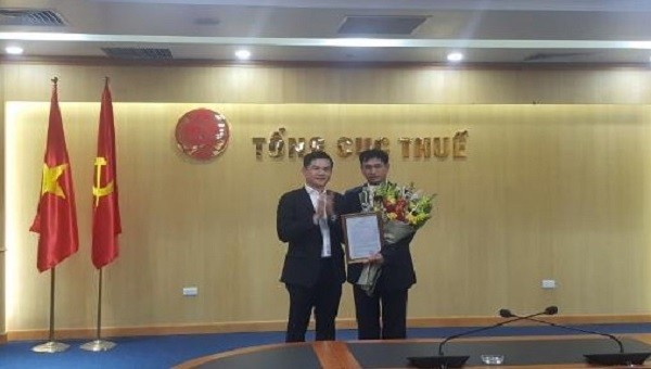 Phó Tổng cục trưởng Tổng cục Thuế Vũ Chí Hùng chúc mừng và tặng hoa cho ông Nguyễn Văn Dương.