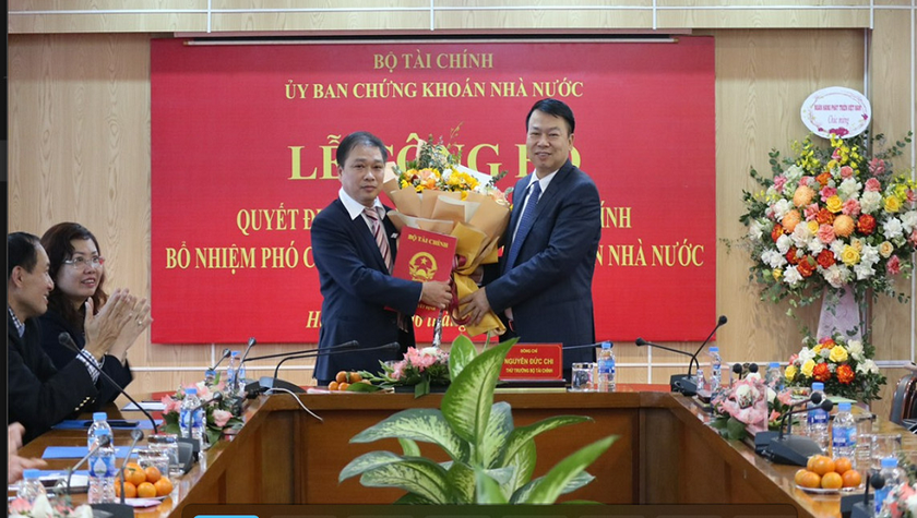 Thứ trưởng Bộ Tài chính Nguyễn Đức Chi trao quyết định và chúc mừng Phó Chủ tịch UBCKNN Lương Hải Sinh.