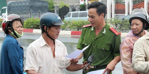 Công an huyện Chơn Thành phát thư vận động cho người dân đi đường. Ảnh: Phước Tuấn