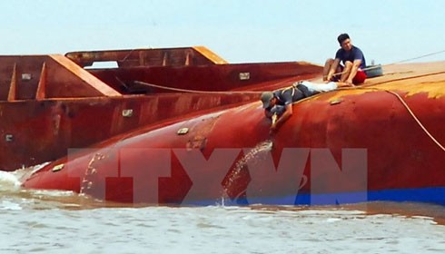 Lực lượng cứu hộ triển khai hàn cắt, phá lớp vỏ tàu để tìm kiếm 4 người còn mất tích. (Ảnh: Mạnh Linh/TTXVN)