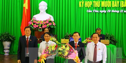 Chủ tịch UBND tỉnh Cần Thơ Võ Thành Thống (thứ hai, bên phải) nhận hoa chúc mừng. (Ảnh: Ngọc Thiện/TTXVN)